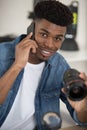 man working on camera lens while making call on smartphone