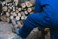 Man working with a chainsaw sawing a large log, harvesting firewood Royalty Free Stock Photo