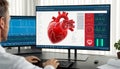 Man working on computer with heart on screen, closeup. Cardiology concept