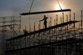 Man working on construction site with scaffold and building with sunset background,scaffolding for construction factory Royalty Free Stock Photo