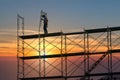 Man working on construction site with scaffold and building with sunset background,scaffolding for construction factory Royalty Free Stock Photo