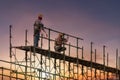 Man working on construction site with scaffold and building with sunset background,scaffolding for construction factory Royalty Free Stock Photo