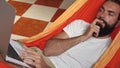 Man working on digital laptop, thinking and find solution in hammock at home Royalty Free Stock Photo