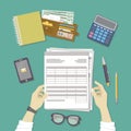 Man working with documents. Human hands hold the accounts, payroll, tax form. Workplace with papers, blanks, forms, phone. Royalty Free Stock Photo