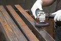 A man working with electric angle grinder tool. Removing rust a metal square tube. Royalty Free Stock Photo