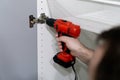 Man working with an electrical drilling machone. Mounting furniture in a new house or apartment as a DIY project Royalty Free Stock Photo