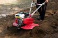 Man working in the garden with garden tiller machine. Garden tiller to work, close up