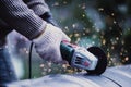 Man working with grinder saw, close up view on tool. Electric saw and hands of worker with sparks. Worker cutting metal