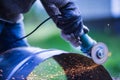 Man working with grinder saw, close up view on tool. Electric saw and hands of worker with sparks. Worker cutting metal