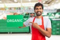 Man working at grocery store presenting organic text on paper