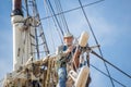 Man working at heights on a sailboat mast Royalty Free Stock Photo