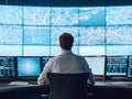 A man working at a high-tech command center, analyzing data on multiple screens in a futuristic environment Royalty Free Stock Photo