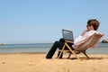 Man working at his pc at the beach