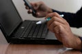 Man working at home, holding a pen, working with a notebook computer Royalty Free Stock Photo