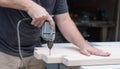 A man working on a home improvement project drilling into wood. Royalty Free Stock Photo