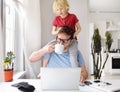 Man working from home with laptop during quarantine. Home office and parenthood at same time. Exhausted parent with hyperactive Royalty Free Stock Photo