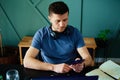 Bored man playing smartphone while working at home office Royalty Free Stock Photo