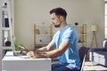 Man working at home or at office on a laptop computer and writing at the desk making notes. Royalty Free Stock Photo