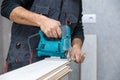 Man working with jigsaw on wood laminate