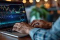 A man working on a laptop, analyzing a stock chart displayed on the screen, Implementing trading algorithms for automated trading Royalty Free Stock Photo