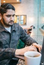 Man working with laptop in cafe next to window. tea or coffee