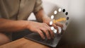 Man working on a laptop computer, downloading and updating software, while waiting for digital files to load from a website.
