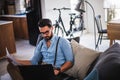 Man working on laptop computer while sitting on sofa Royalty Free Stock Photo