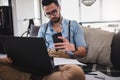 Man working on laptop computer while sitting on sofa Royalty Free Stock Photo