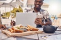 Man working on laptop eating lunch at restaurant, business meeting with friends and planning collaboration with food at Royalty Free Stock Photo