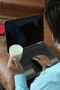 Man is working in laptop and holding coffee cup in hand Royalty Free Stock Photo