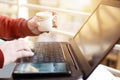 Man is working on the laptop with holding tea cup in hand Royalty Free Stock Photo