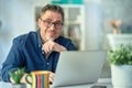 Man working with laptop in home office sitting at desk Royalty Free Stock Photo