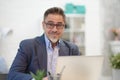 Man working with laptop in home office sitting at desk Royalty Free Stock Photo