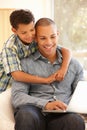 Man working on laptop at home with son Royalty Free Stock Photo