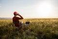 Man working on laptop relaxes in a field at sunrise. Royalty Free Stock Photo