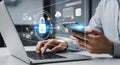 Man working on laptop and smartphone with cybersecurity and data protection interface Royalty Free Stock Photo