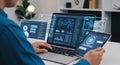 Man working on laptop and tablet with futuristic data interfaces Royalty Free Stock Photo
