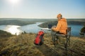 Man working on laptop on top mountains and relaxes near river at sunset. Royalty Free Stock Photo