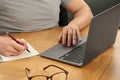 Man working with laptop at wooden table, closeup Royalty Free Stock Photo