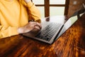 Man working on laptop on a wooden table. Freelancer works in a country house. Close-up photo Royalty Free Stock Photo