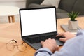 Man working with laptop at wooden table indoors, closeup Royalty Free Stock Photo