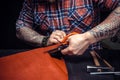 Man working with leather using crafting scissors