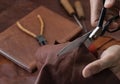 Man working with leather using scissors. Royalty Free Stock Photo