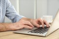 Man working with modern laptop at wooden table indoors, closeup Royalty Free Stock Photo