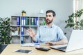 Man working in the office talking on the phone using a small white headset, businessman at work Royalty Free Stock Photo