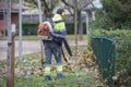 Worker operating heavy duty leaf blower in city park Royalty Free Stock Photo