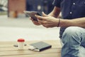 Man working outside in park using modern tablet, notebook, mobile phone. Close-up hands holding personal gadget