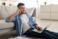 Man working on pc and talking on cellphone at home Royalty Free Stock Photo