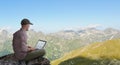 Man working remotely outdoors with laptop