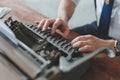 Man working on retro typewriter at desk in parlor room Royalty Free Stock Photo